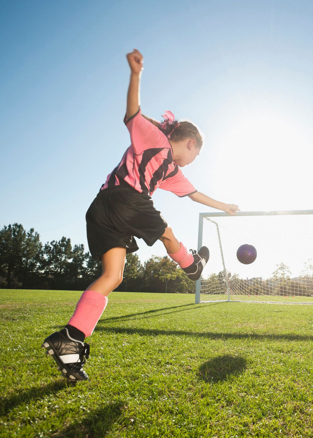 Dievča kope futbalová lopta do brány