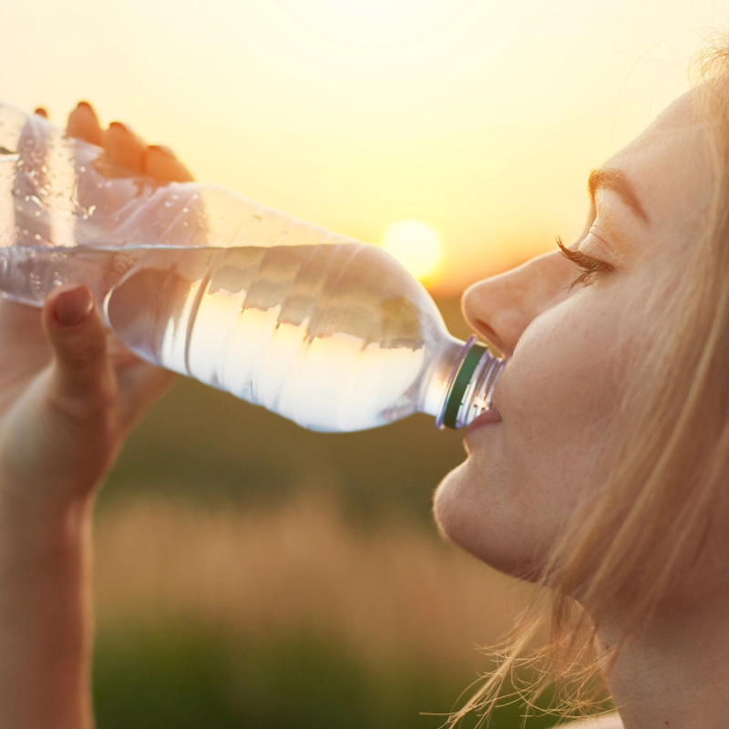 Mladá žena pijúca vodu z plastovej fľaše