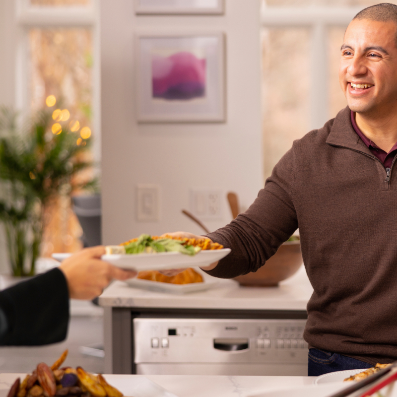 Muž podáva tanier s jedlom